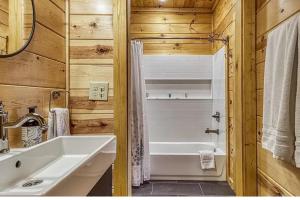 加特林堡Hawk’s View Log Cabin -Mountains in Gatlinburg.的浴室配有盥洗盆和浴缸。