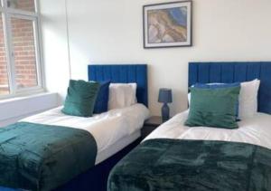 弗特威克Flitwick Luxury Apartment的蓝色和白色的客房内的两张床
