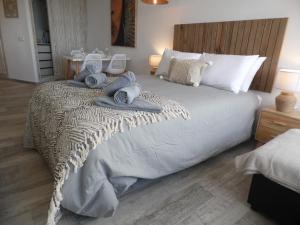 多列毛利诺斯La Torre de la Colina Playa的一间卧室配有一张大床和毛巾