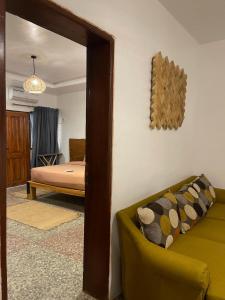 伊巴丹Bonsai Boutique Homes的一间卧室配有一张床、一张沙发和一面镜子