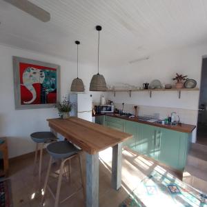 蒙塔古The Little Gem的厨房配有绿色橱柜和木桌
