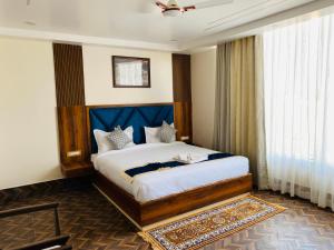 德奥加尔HOTEL MAA LAXMI PALACE的一间卧室配有一张大床和蓝色床头板