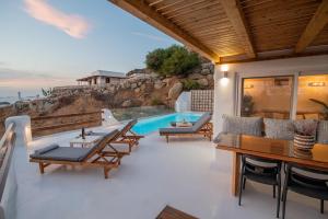 纳克索乔拉Nèsoi Villas Naxos的一个带桌椅的庭院和一个游泳池