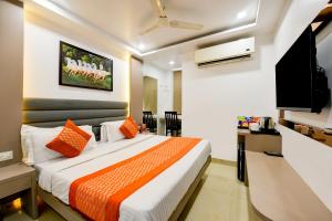 新德里Hotel Bhartia 2 min walk from New Delhi Railway station的配有一张床和一台平面电视的酒店客房