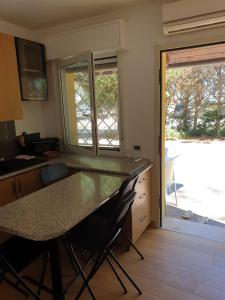 黎都-迪沃拉诺Residence natura beach的厨房配有桌椅和窗户。
