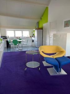 马斯特里赫特PetitGrandeur的一间设有黄色椅子和厨房的房间