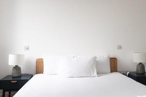 伦敦Lovely 1 Bedroom Apartment Holborn London的卧室配有带两盏灯的白色床