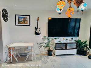 格拉斯哥La Casita, Your Home Away from Home - Free Parking的客厅配有平面电视和桌子。