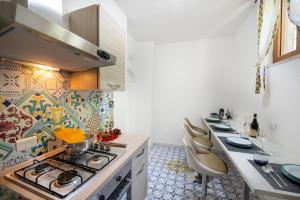 波西塔诺AMORE RENTALS - Casa Barbera A的厨房配有炉灶和一些椅子