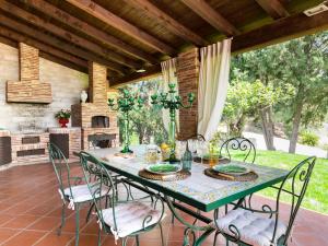 卡尔伦蒂尼Villa Nunziatina的带壁炉的庭院配有桌椅