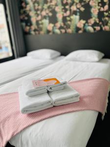 布雷达苏特尔酒店的两张带毛巾的床和一本书
