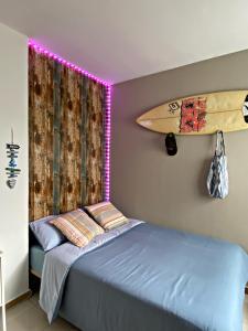 阿雷西费Amanecer Isleño Habitaciones的一间设有一张床铺的房间,墙上设有冲浪板