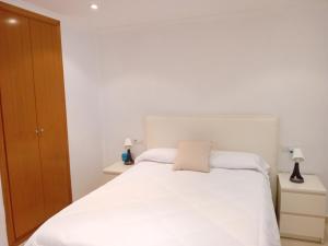 甘迪亚Apartamento Luna的卧室配有白色的床和2个床头柜