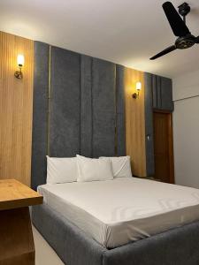 卡拉奇Marigold Accommodations的卧室设有一张白色大床和天花板