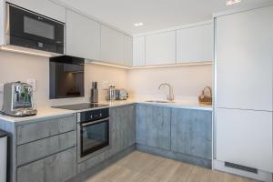 波尔泽斯Polzeath Beach House的厨房配有白色橱柜和不锈钢用具
