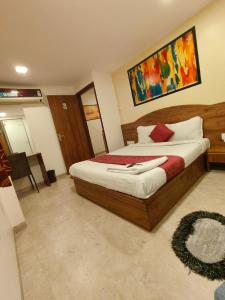 孟买Hotel Beach Crown Juhu的卧室配有一张床,墙上挂有绘画作品