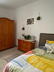 阿雷西费Amanecer Isleño Habitaciones的一间卧室配有一张床和一个木制梳妆台
