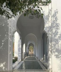 Al ‘UyūnBeit Al-Madina的一条有白色墙壁和拱门的小巷