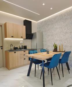 沃洛斯Volos Guesthouse Chrysa的厨房配有木桌和蓝色椅子