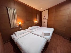 芭东海滩Nanai 2 Residence Patong Phuket的一间卧室配有带白色床单和枕头的床。