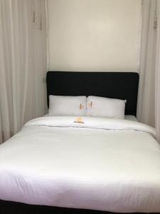 内罗毕TAWALA GARDEN HOTEL的一张带两个枕头的大白色床
