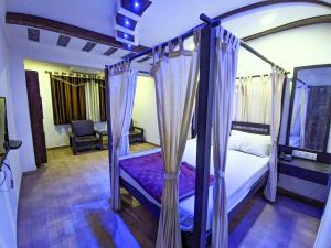 曼德维KRL Inn的一间卧室配有一张带紫色床单的天蓬床
