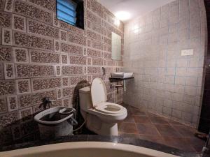 曼德维KRL Inn的浴室配有卫生间、盥洗盆和浴缸。