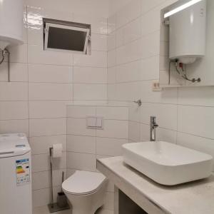 蒙达尼耶Apartments Tinjarosa的白色的浴室设有水槽和卫生间。
