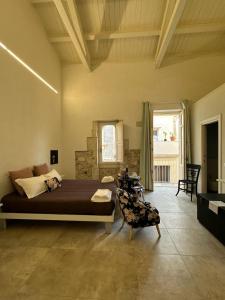 锡拉库扎Archè的一间卧室,卧室内配有一张床和一把椅子