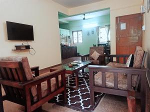 VelcaoBenirosa Homestay Apartments 2的客厅配有桌椅和电视。