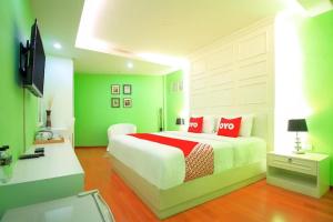 DusitSabai Dee Minitel的绿色和白色的卧室,配有红色枕头的床