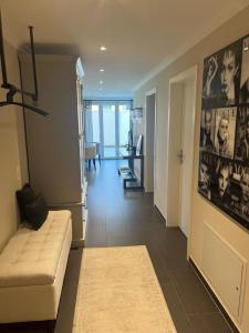 埃申Appartement ALLURE 4 Zimmer Gartenwohnung的带沙发的客厅和带走廊的房间