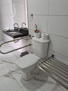 大普拉亚Pousada Vila Real PG的白色的浴室设有卫生间和水槽。