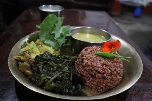 图利凯尔Hasera Organic Farmstay: Farm to Table & Mountain View的餐桌上放着一盘饭和蔬菜的食物