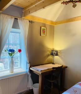 TingsrydSkrattande Ko的一间卧室配有一张桌子和一扇花瓶的窗户