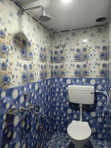 普里JHARANA GUEST HOUSE的蓝色和白色的浴室设有卫生间