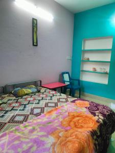 普里JHARANA GUEST HOUSE的一间卧室配有一张带彩色毯子的床