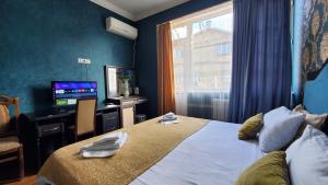 第比利斯Hotel Antalia的酒店客房,配有床和电视