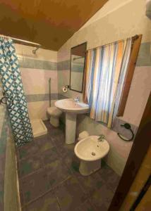 西尼斯科拉Villaggio Camping Calapineta的一间带水槽、卫生间和镜子的浴室