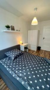 华沙Warszawa Centrum Pokoje的一间卧室配有一张大床,床上铺有白色星星的蓝色毯子