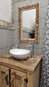 拉斯彭尼塔斯Mano a Mano Eco Hostal的浴室设有水槽和镜子,位于柜台上
