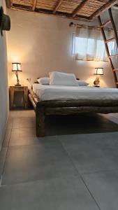拉斯彭尼塔斯Mano a Mano Eco Hostal的一间卧室配有一张木架大床
