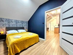 Duże Apartamenty na 102的一间卧室设有一张床和蓝色的墙壁