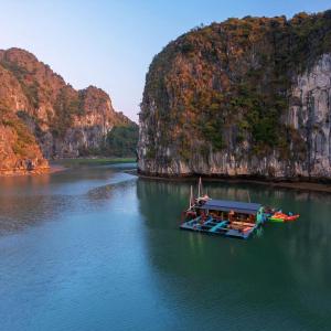 吉婆岛Eco Floating Farm Stay Cai Beo的山边的水中小船