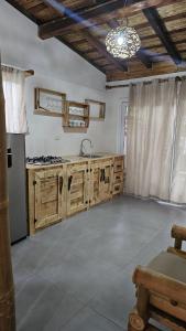 拉斯彭尼塔斯Mano a Mano Eco Hostal的一个带木制橱柜和水槽的厨房