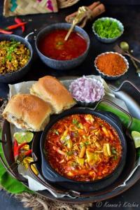 孟买Hotel the pacific Chakala的餐桌,带一盘食物和一碗食物