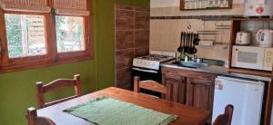 波特雷里约斯Cabañas Rowal的厨房配有桌子、炉灶和冰箱。