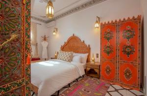 非斯Riad Fes Madaw的一间卧室配有一张大床和华丽的床头板