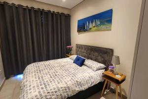 DensainagarLow Tide的一间卧室配有一张带蓝色枕头的床。