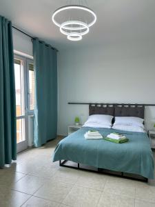 坎波巴索Puzzle Rooms的一间卧室配有一张带绿床单和吊灯的大床